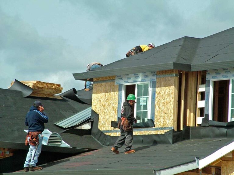 Homeowner sorting asphalt shingles, metal flashing, and roofing felt into separate covered containers.